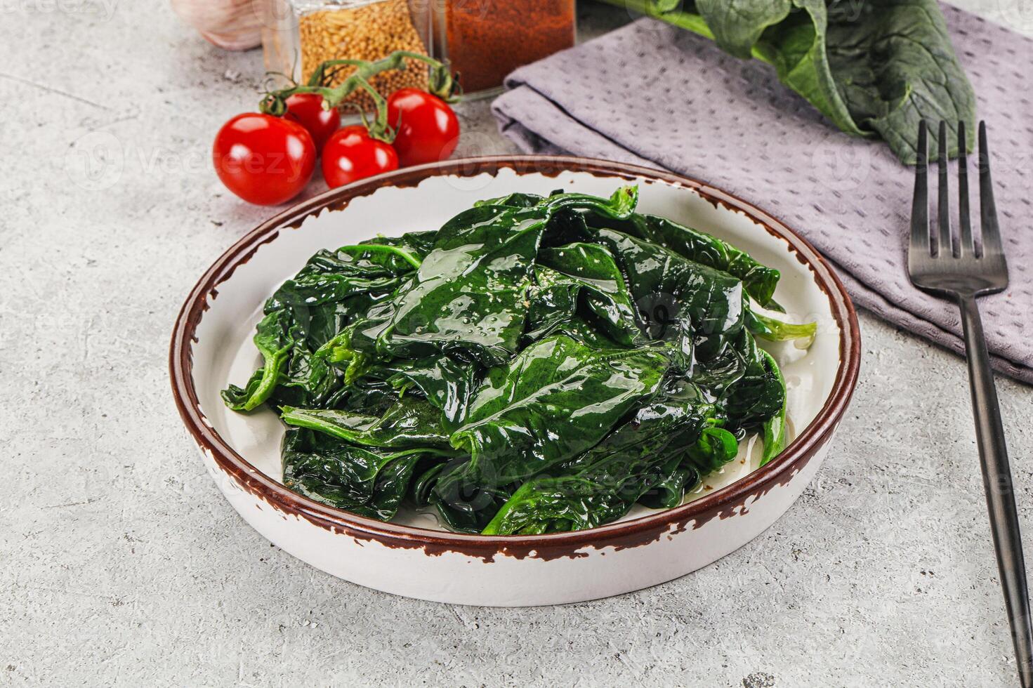 Spinach in a bowl with a fork and knife photo