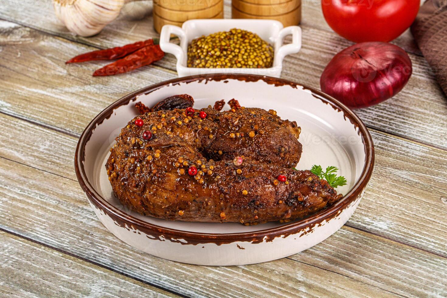 A plate with a piece of meat on it and some spices photo