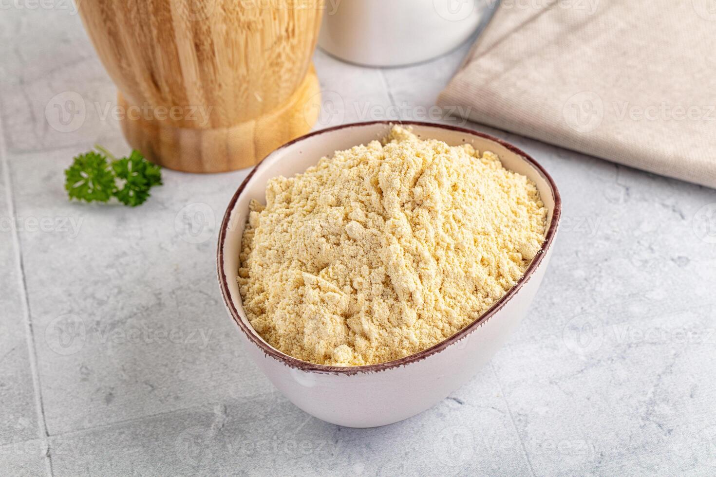 A bowl of rice next to a wooden spoon and a wooden bowl photo