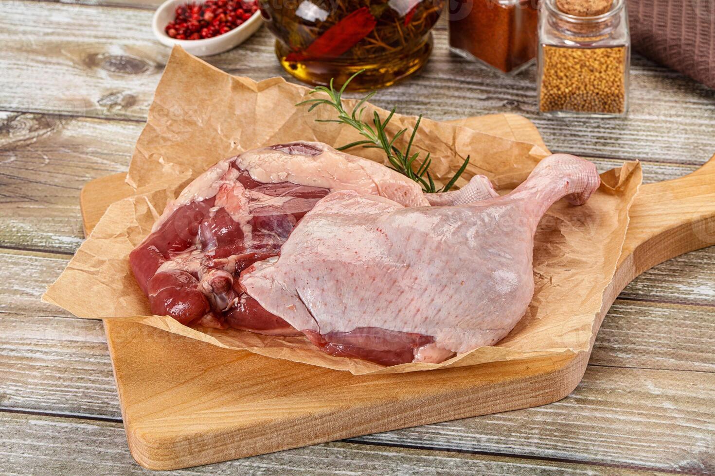 A chicken on a cutting board with spices and herbs photo