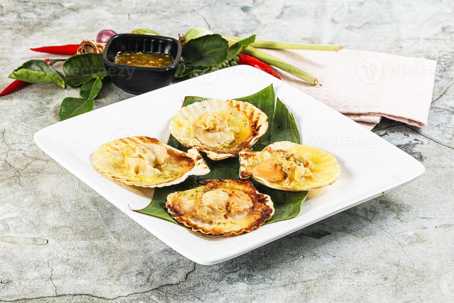 A plate with scallops on top of a green leaf photo