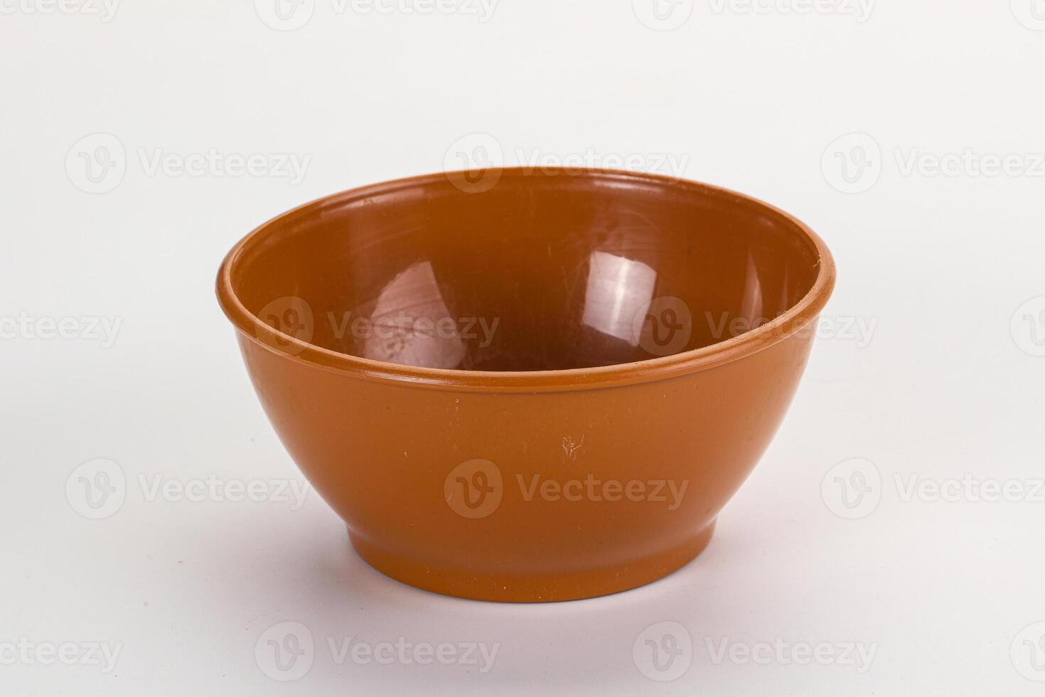A small orange bowl on a white surface photo