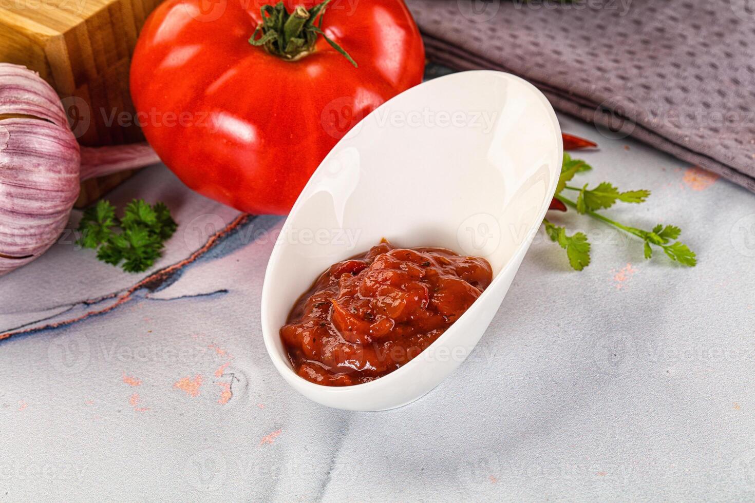 A white bowl with tomato sauce and garlic photo