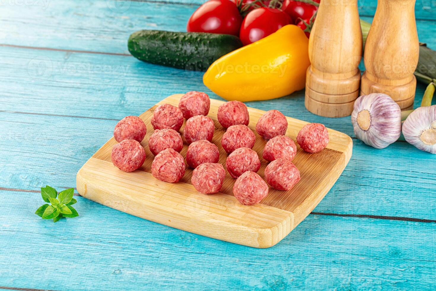 Meatballs on a cutting board with vegetables photo