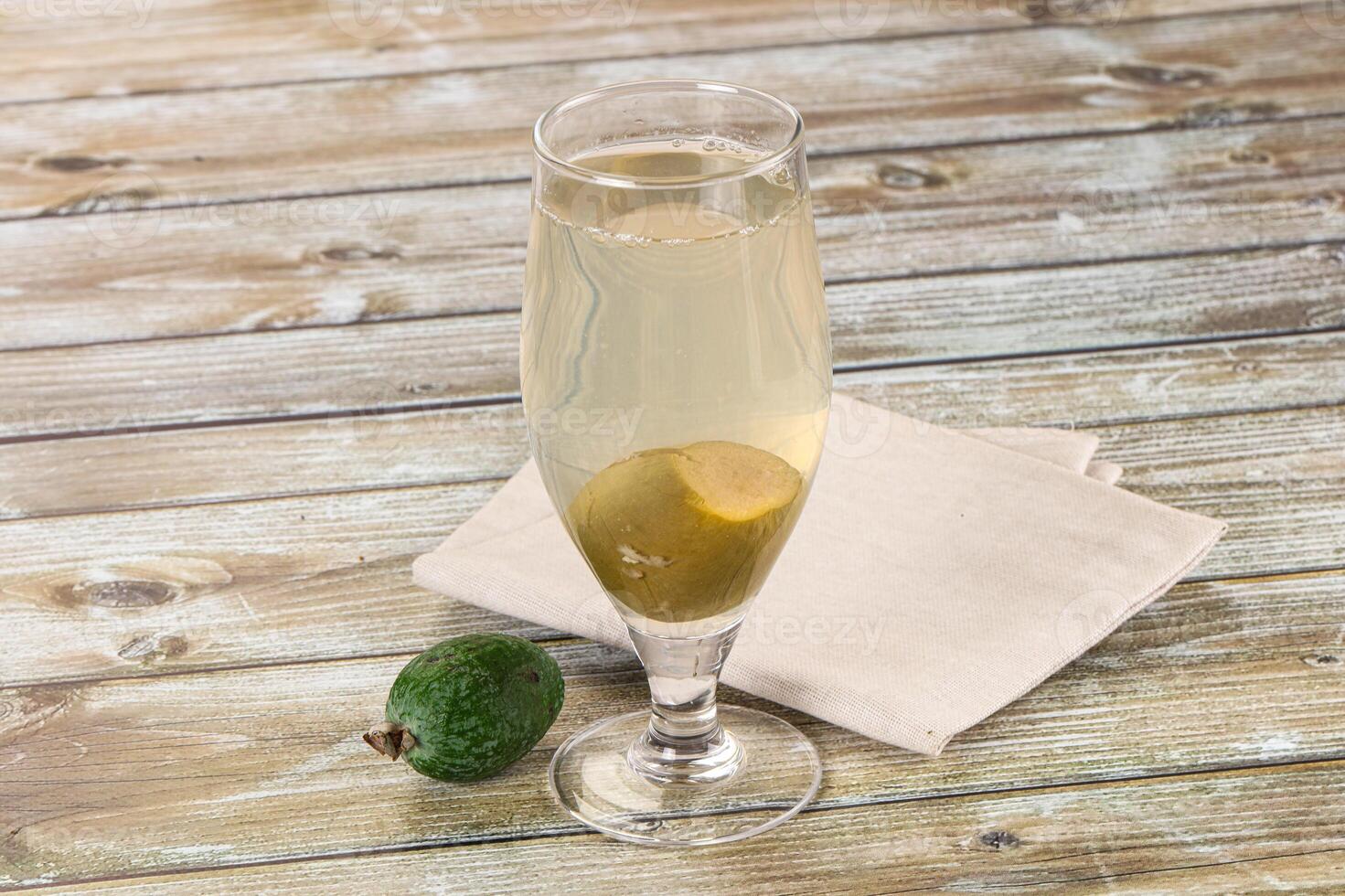 A glass of white wine with an avocado on a napkin photo