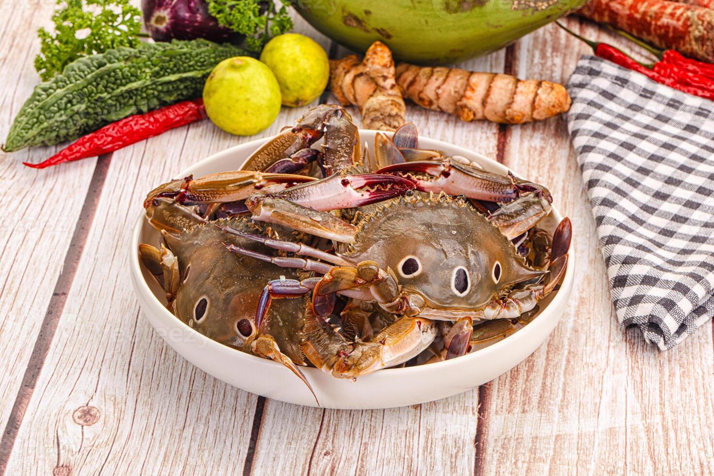 A bowl of crabs on a table with a knife and a knife photo