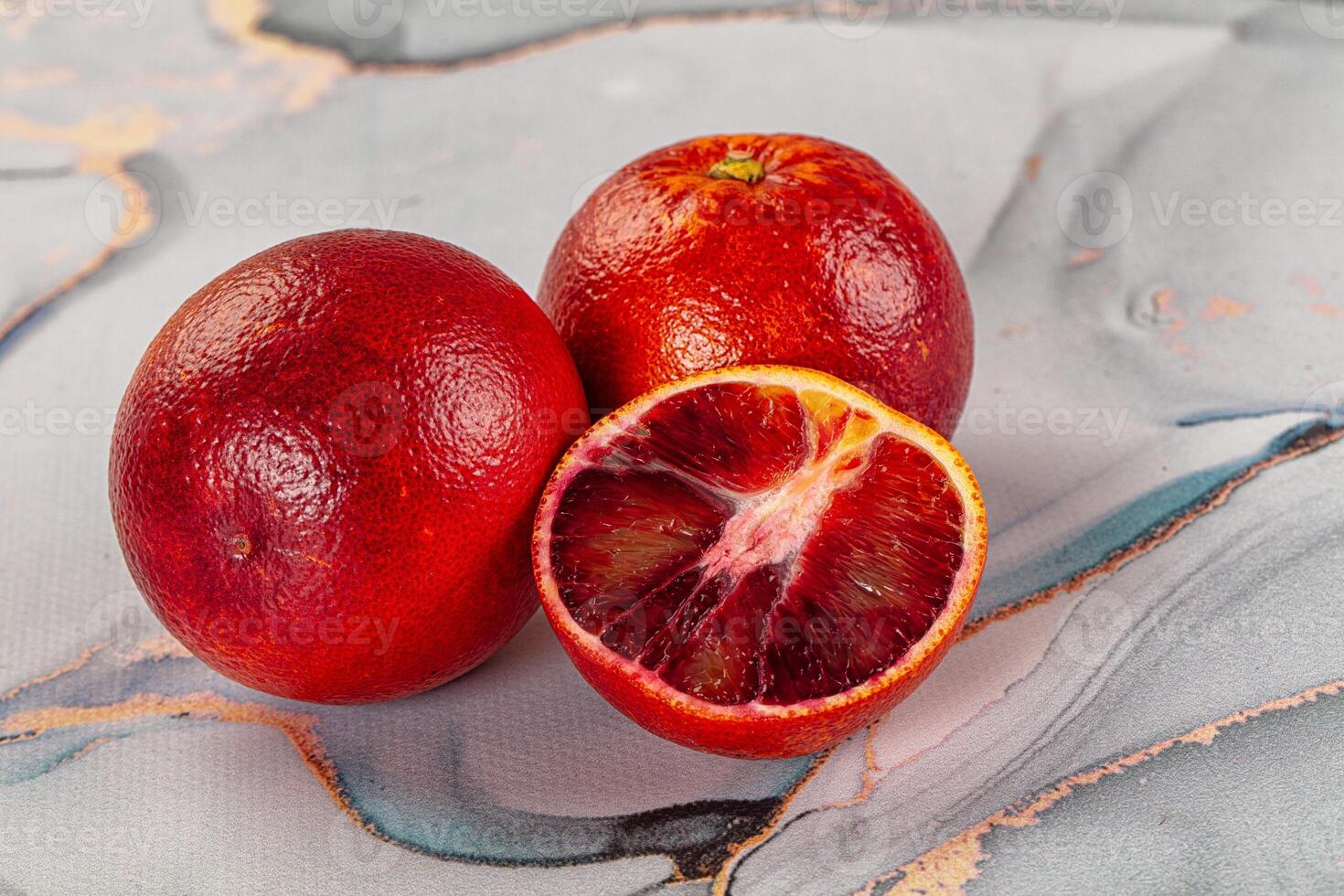 A close up of two red fruits on a marble surface photo