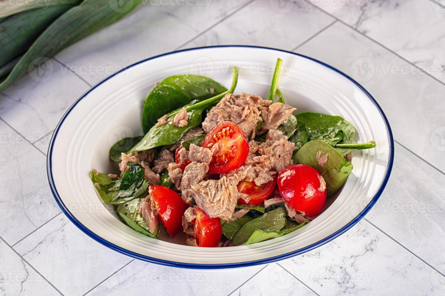 A bowl of spinach and tuna salad with tomatoes photo