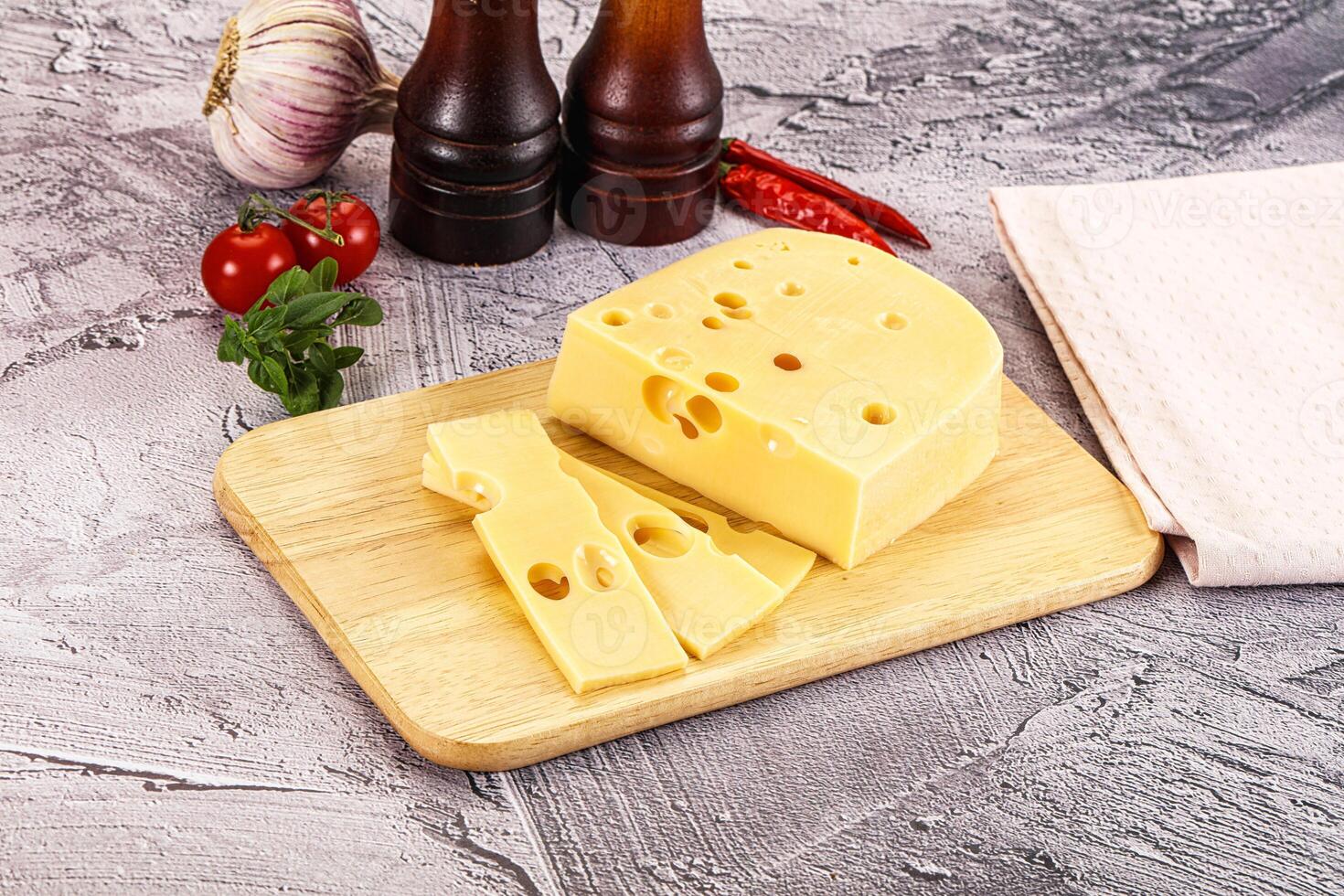 A cheese board with a slice of cheese and a bottle of ketchup photo