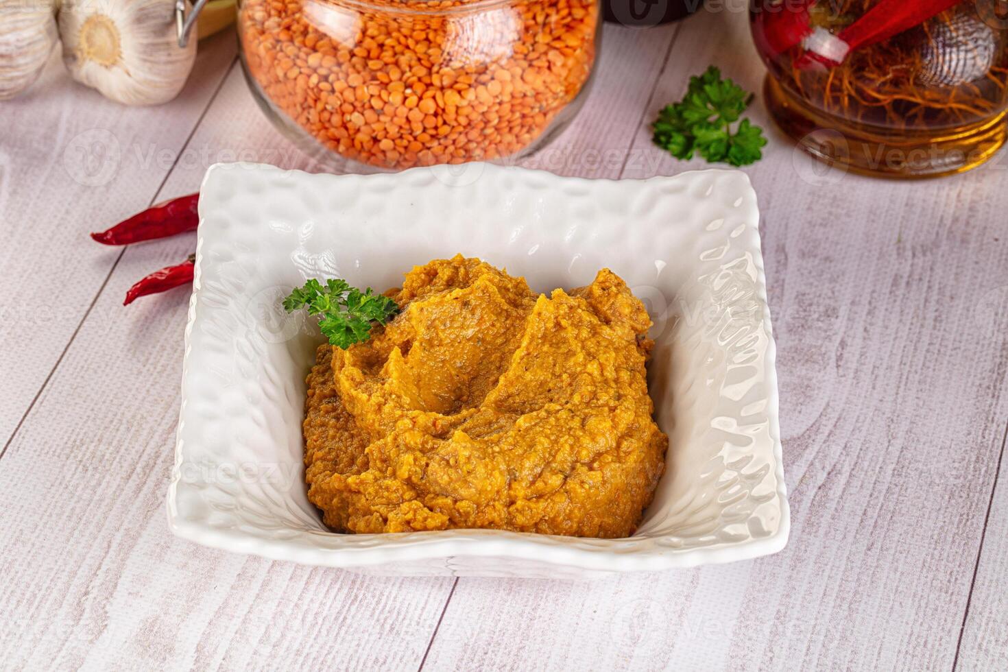 A bowl of hummus with spices and herbs photo