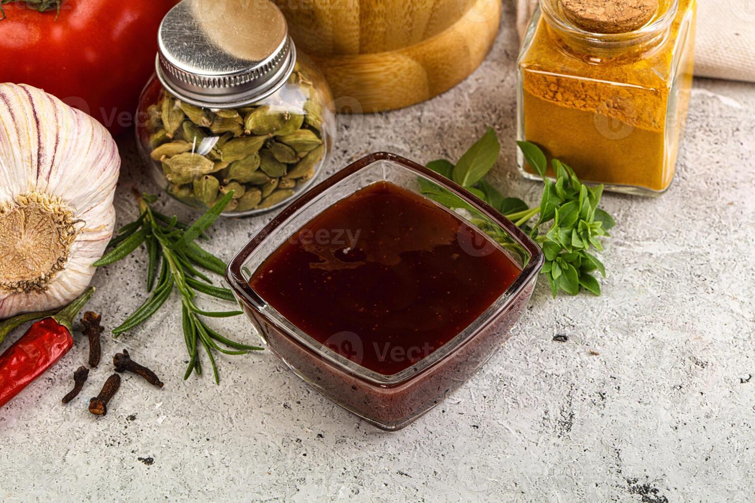 A bowl of sauce, spices, and vegetables photo