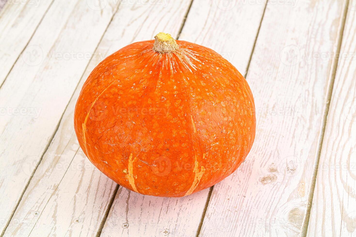 A pumpkin sitting on a white table photo