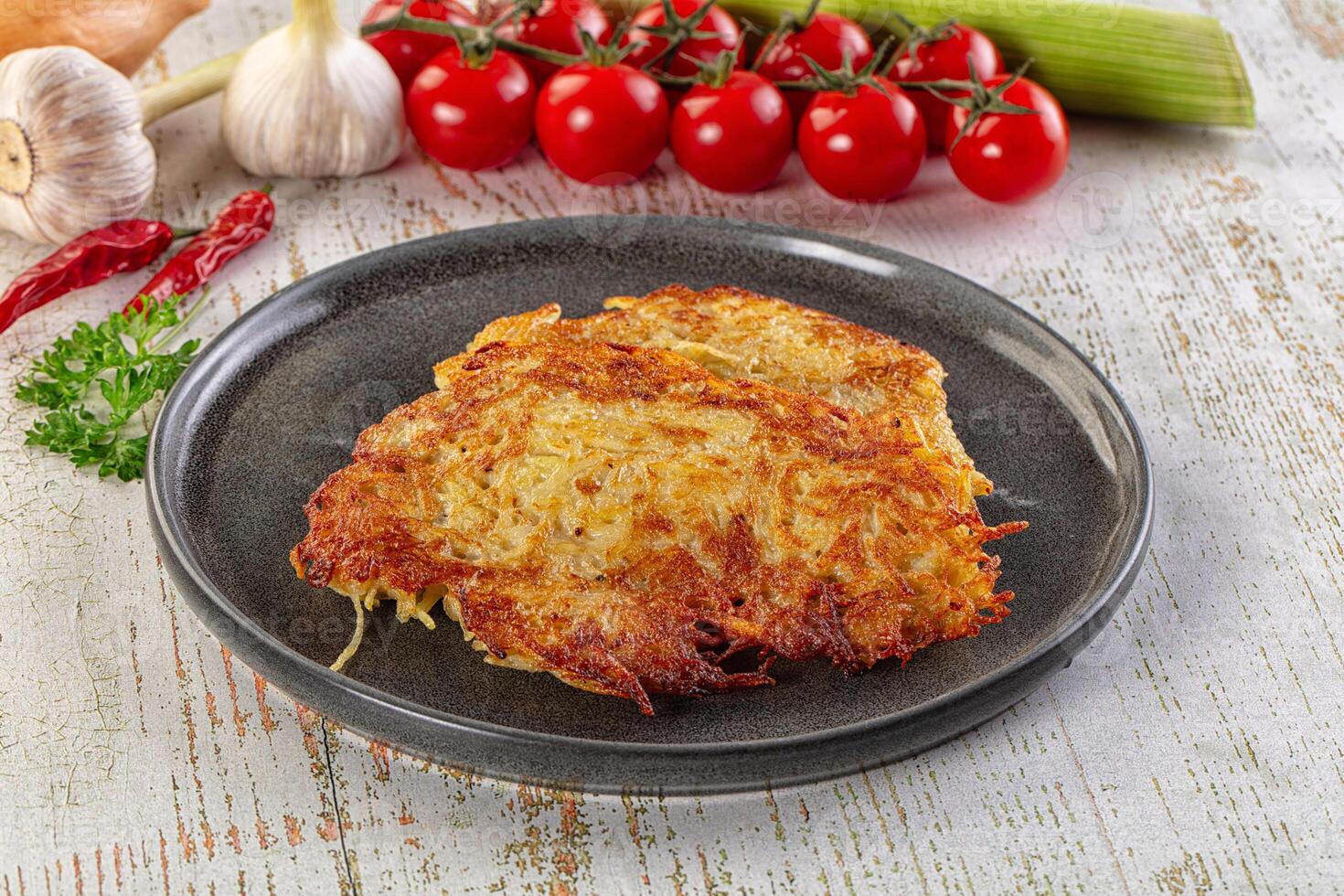 A plate of potato pancakes with vegetables and herbs photo