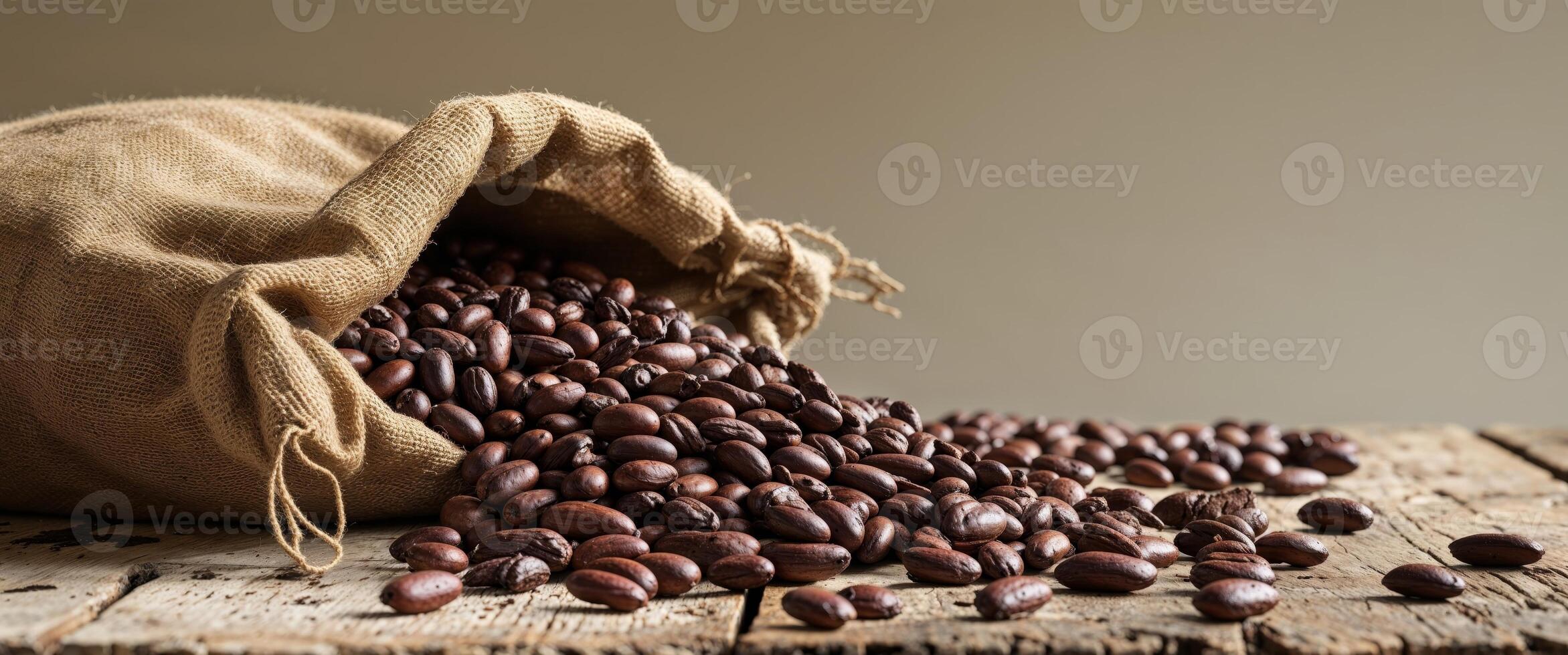 Rustic setting with cocoa beans spilling from burlap sack on wooden table in workshop. photo
