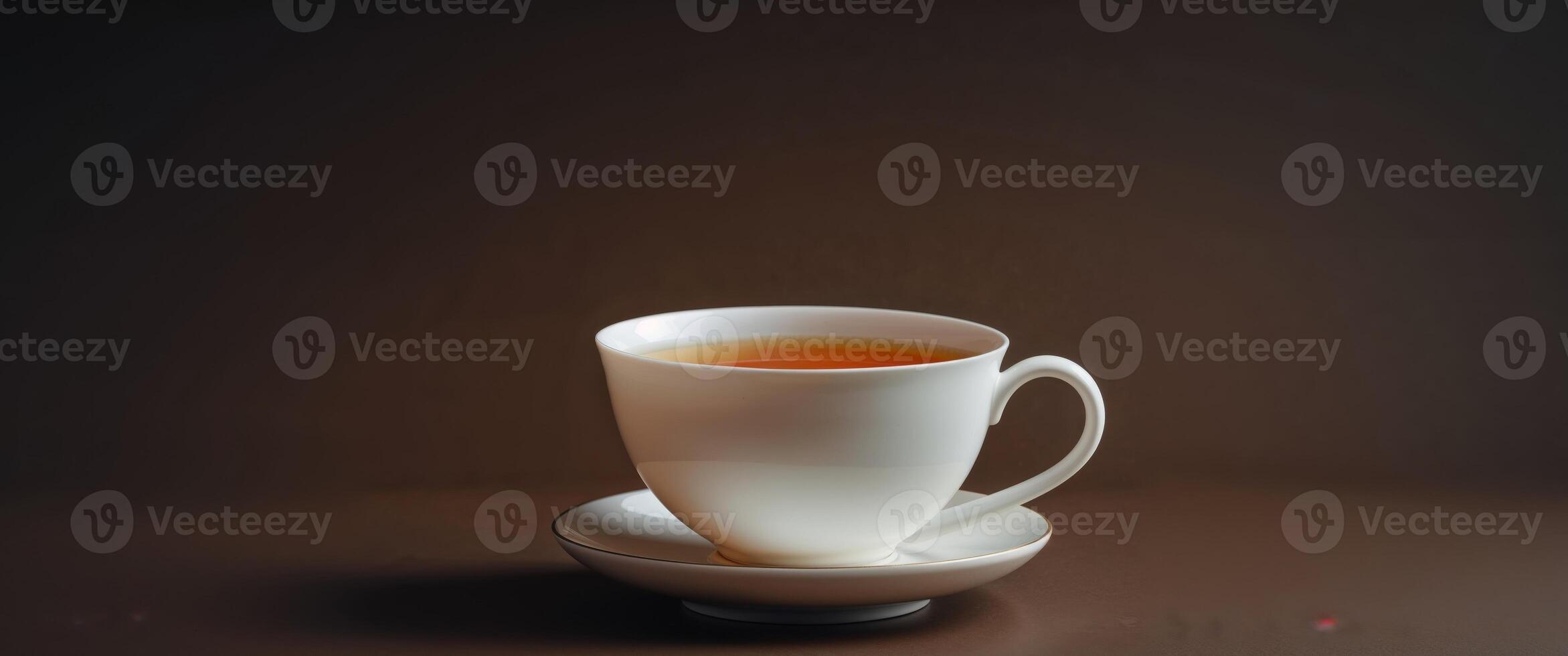 Amber Tea in White Ceramic Cup on Dark Background photo