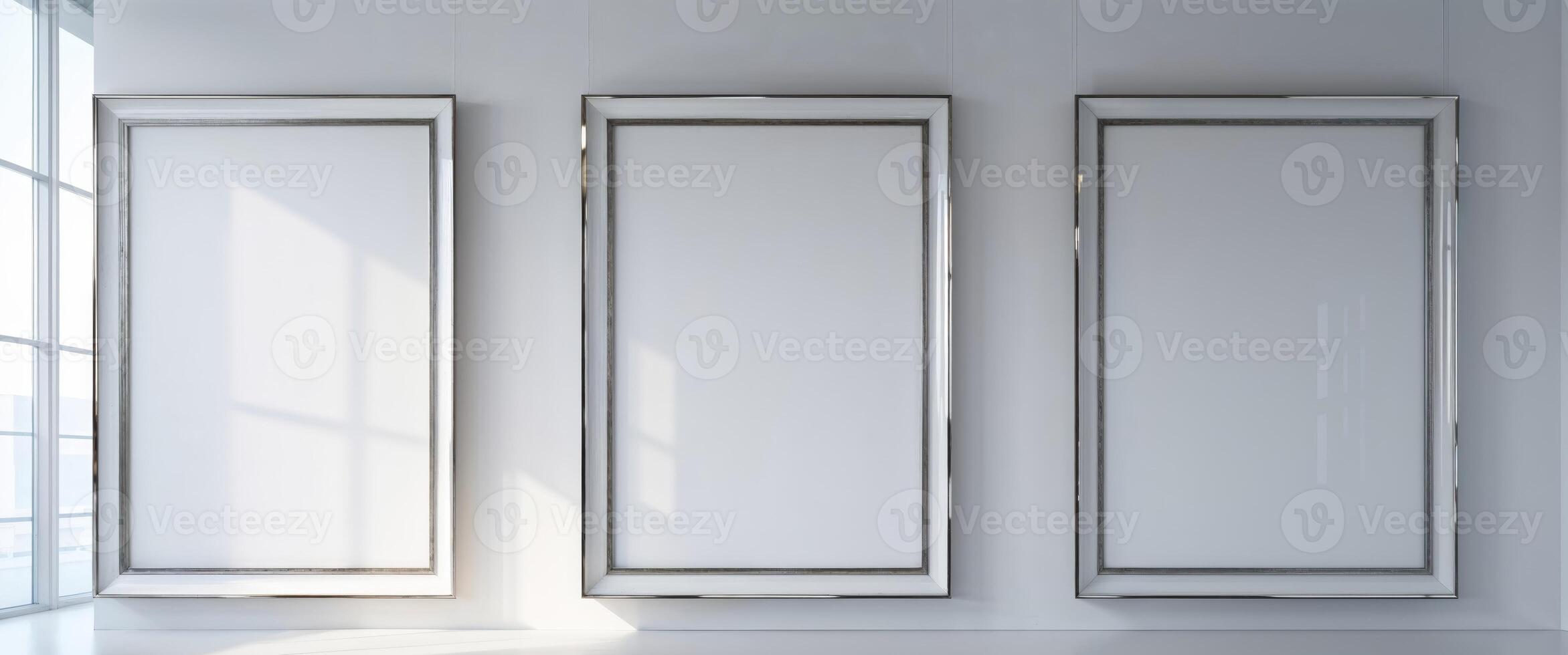 Three large blank white picture frames hang symmetrically on the wall in an art gallery. photo