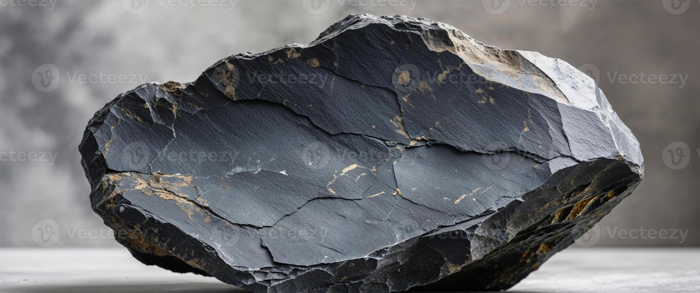 Dark slate rock with an irregular shape and rich texture. photo