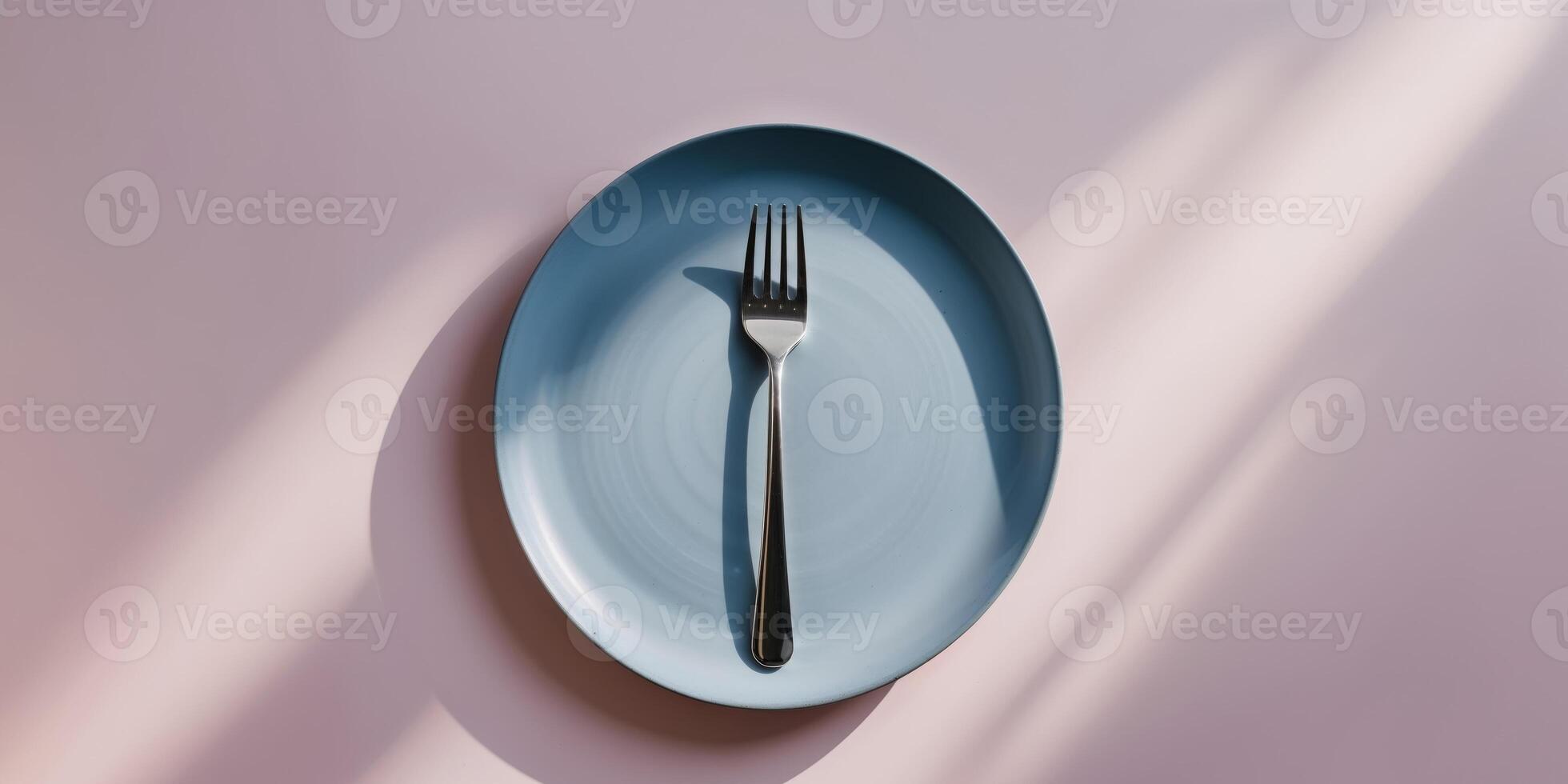 Top View of Blue Plate with Silver Fork on Pastel Pink Background in Minimal and Modern Style photo