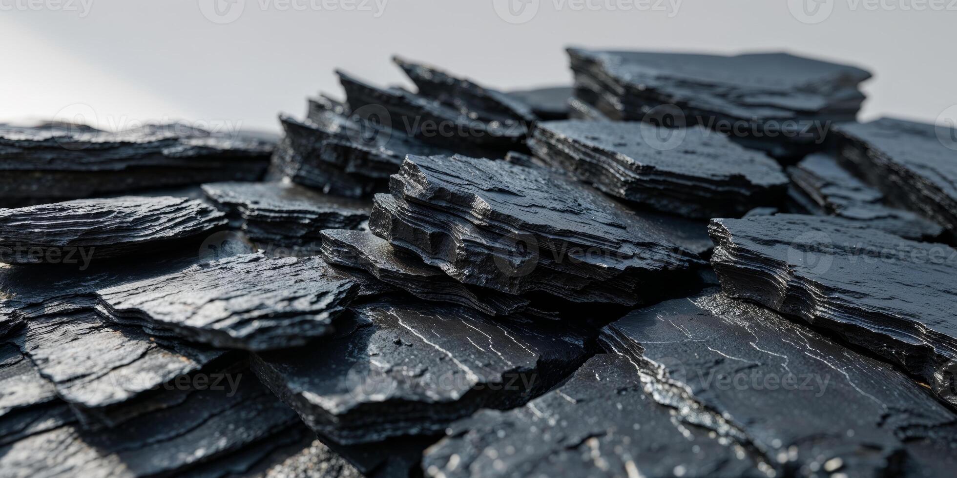 Closeup of layered black rocks with sharp rugged textures and natural shadows photo