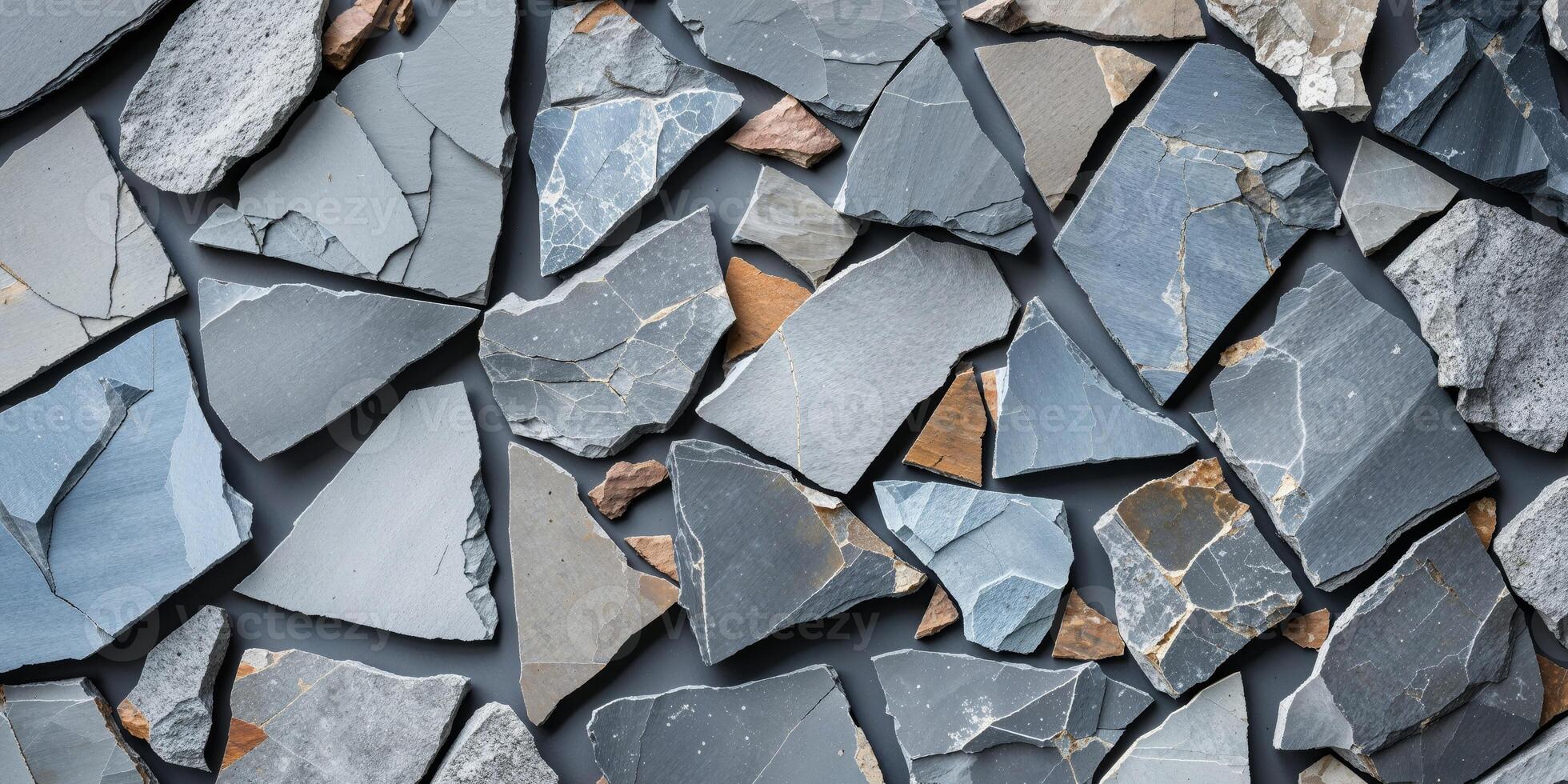 Broken slate pieces forming textured abstract stone background in natural gray tones photo