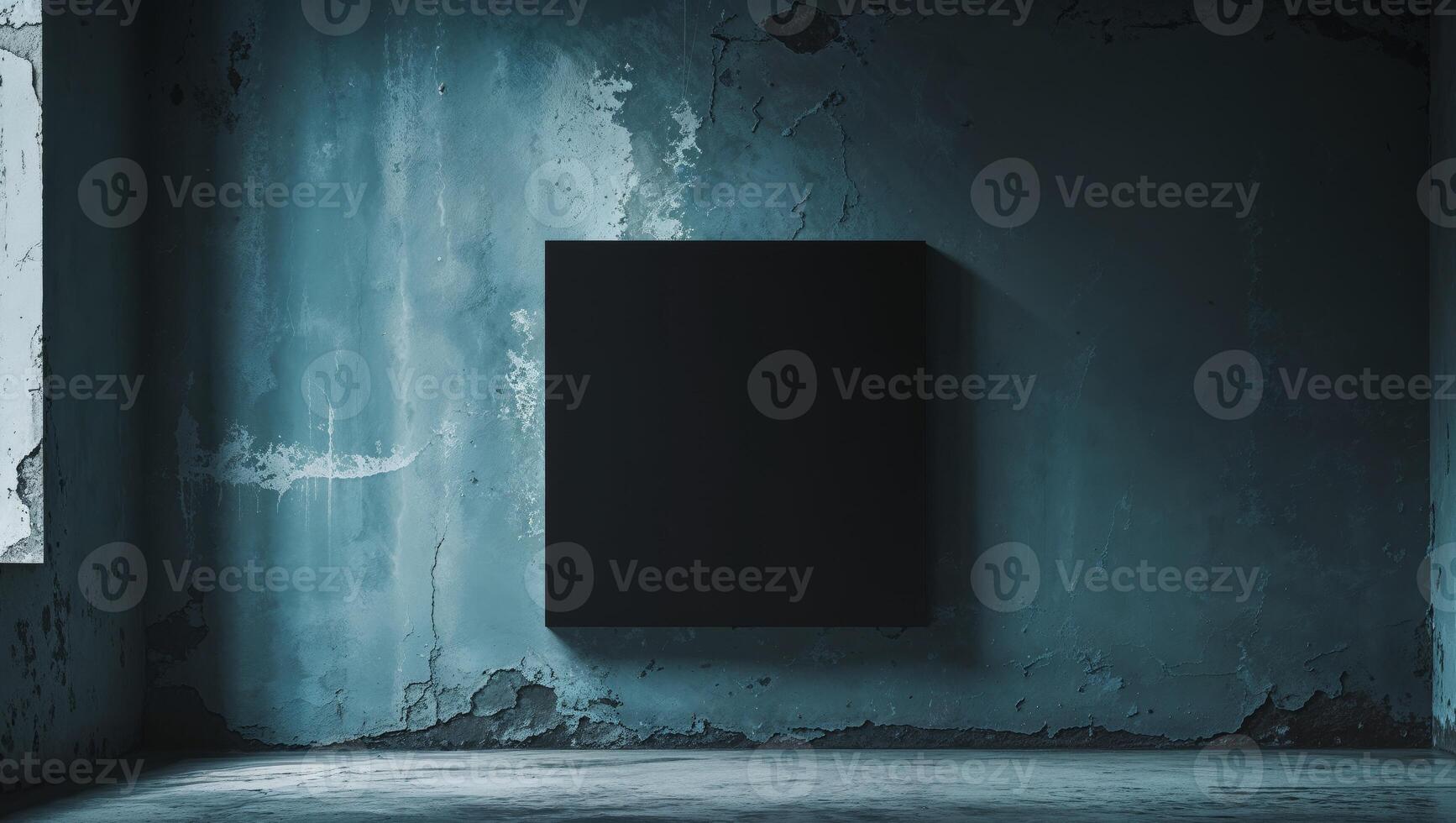 Black square canvas hanging on a grunge blue wall in empty room photo