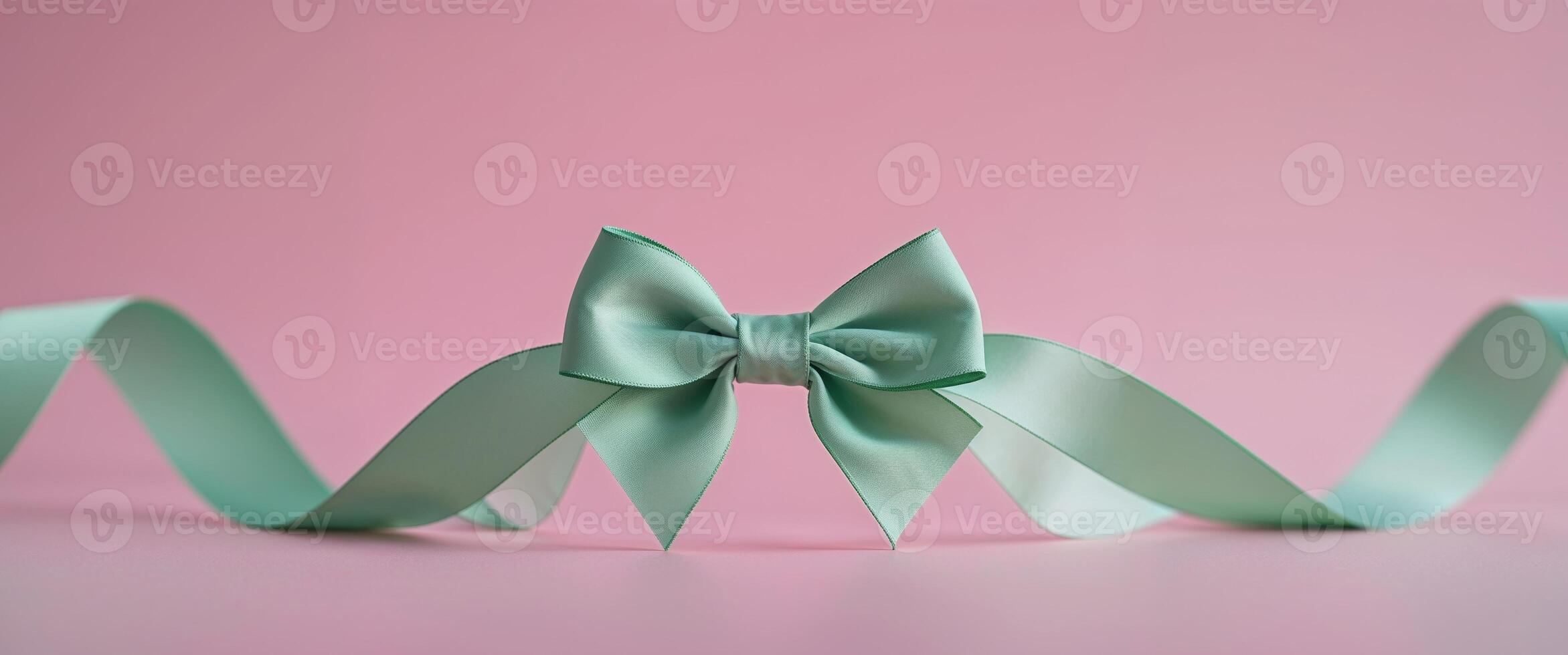 A green bow on a pink background photo