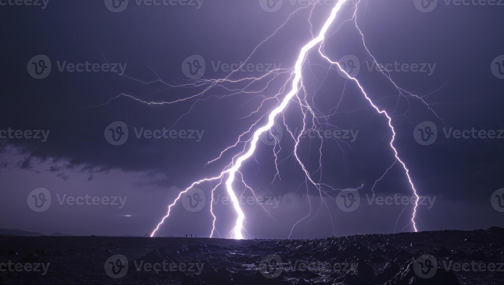 Lightning strikes over a dark sky with a large mountain in the background photo
