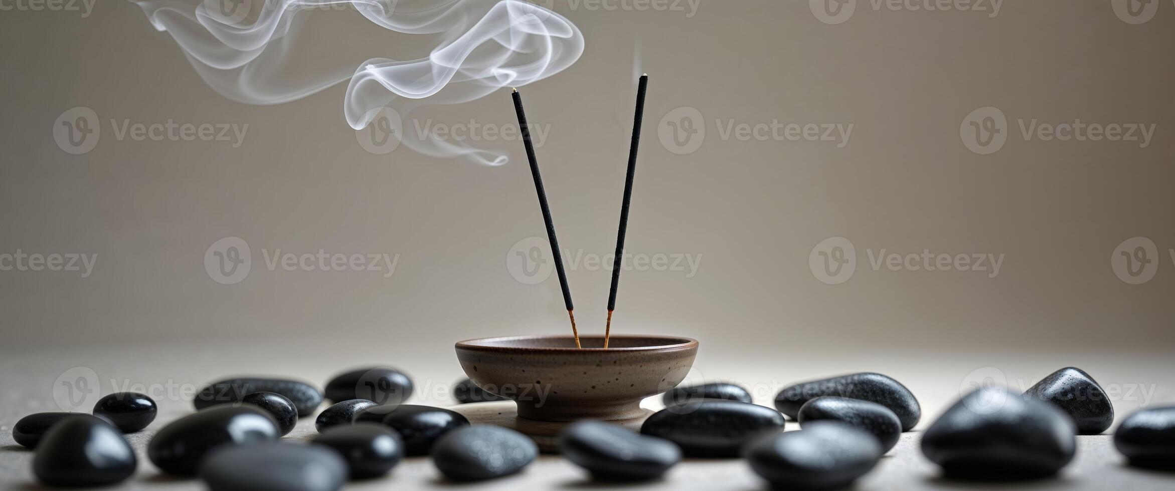 An incense stick and some stones on a table photo