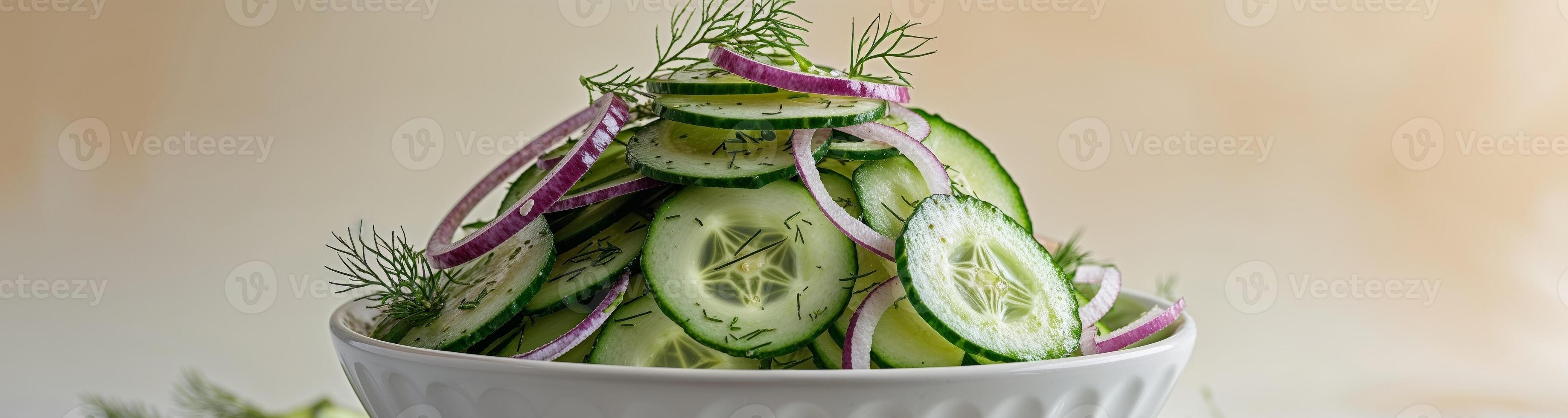 Fresh Thinly Sliced Cucumber Salad with Onions and Dill in a White Bowl on a Light Background photo
