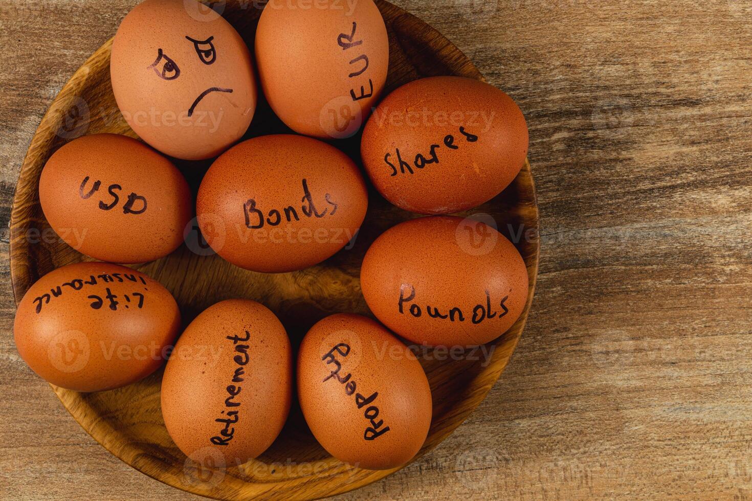 Investment concepts represented with eggs on a wooden plate photo