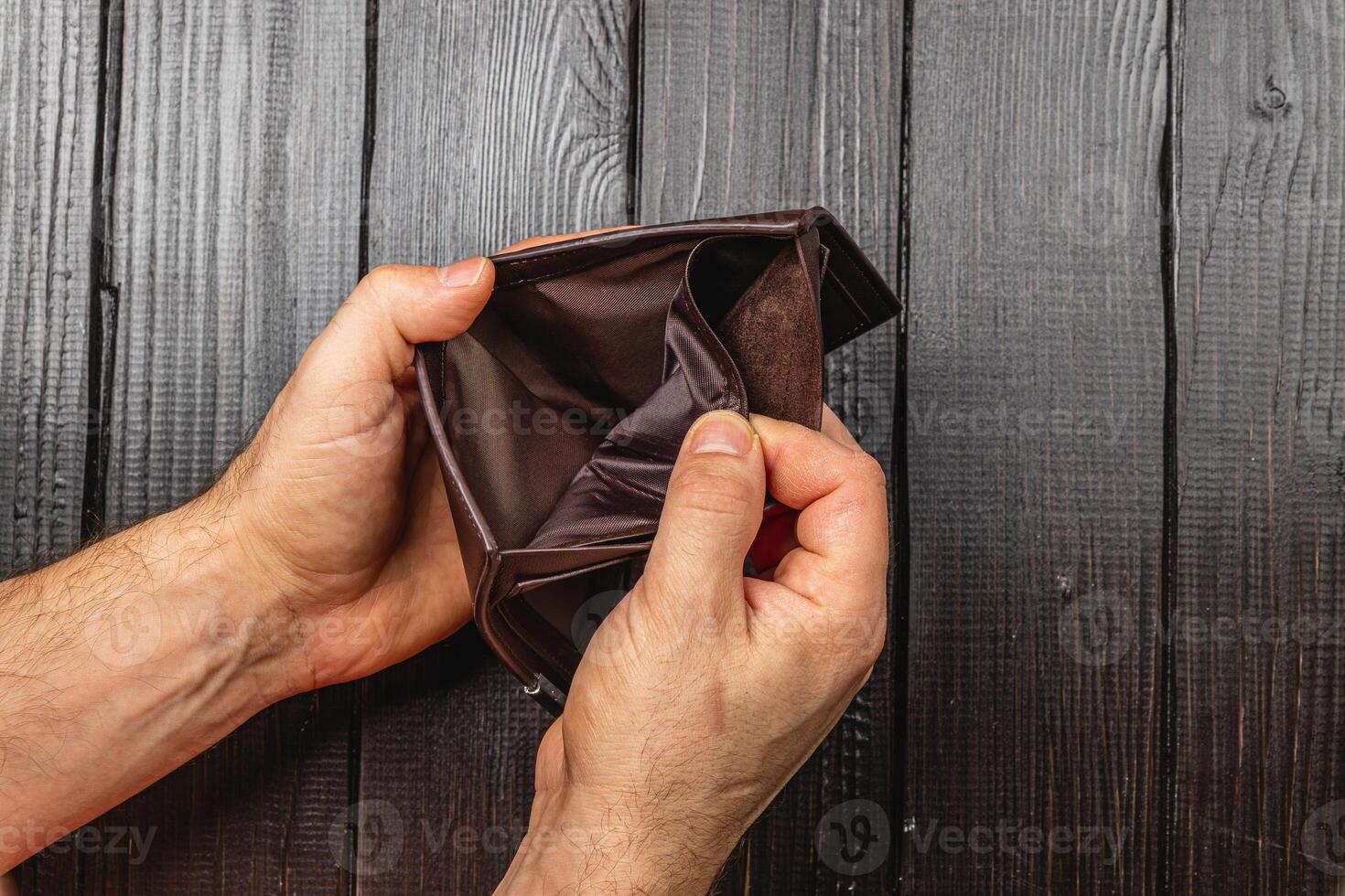 Despair in finance as businessman examines empty wallet amidst economic crisis photo