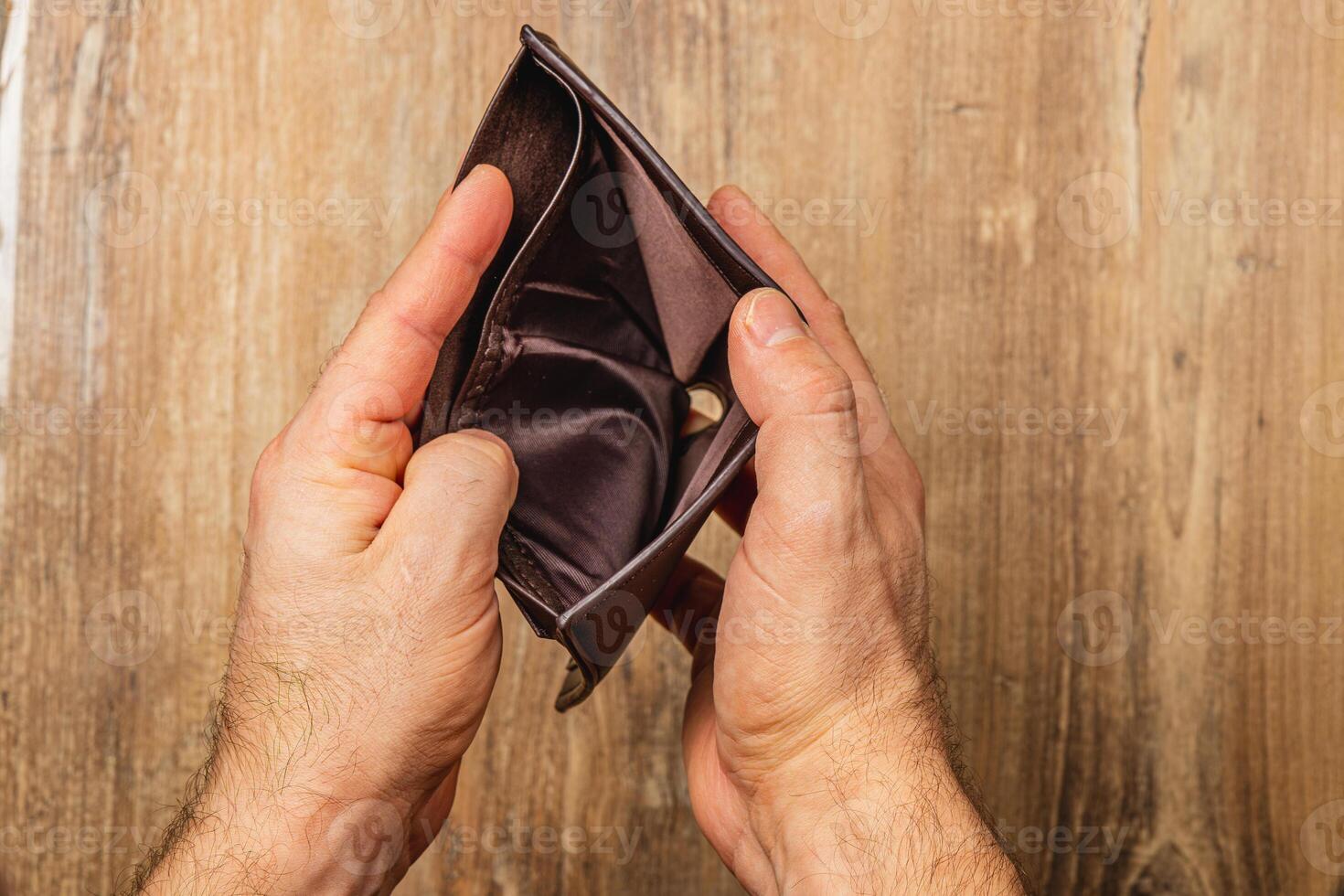 Struggling businessman confronts financial crisis with empty wallet in hands photo