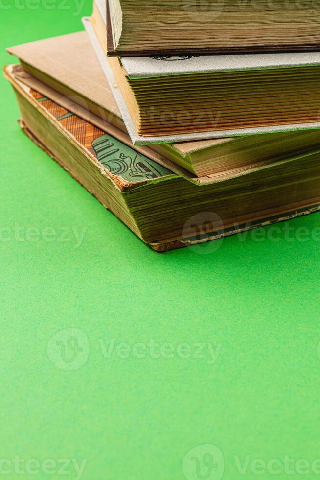 Stack of vintage books resting on green background in a cozy atmosphere photo