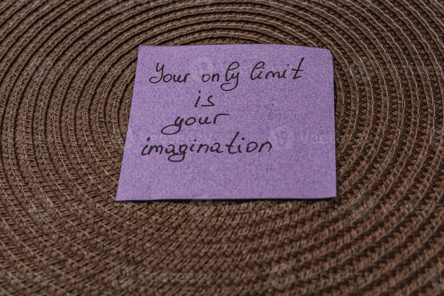 Inspirational message on a purple sticky note placed on textured surface photo