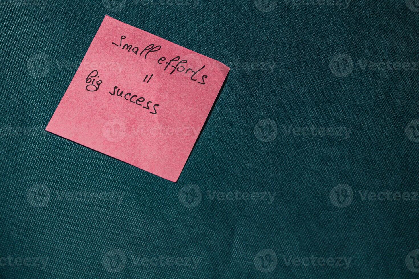 Inspirational note on a pink sticky notepad on a green background photo