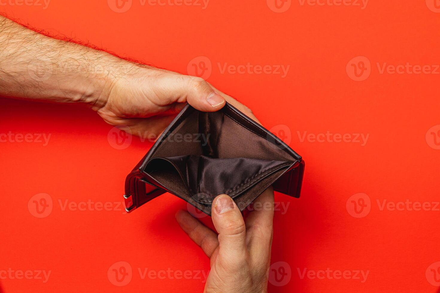 Financial struggle is evident as a man inspects his empty wallet photo