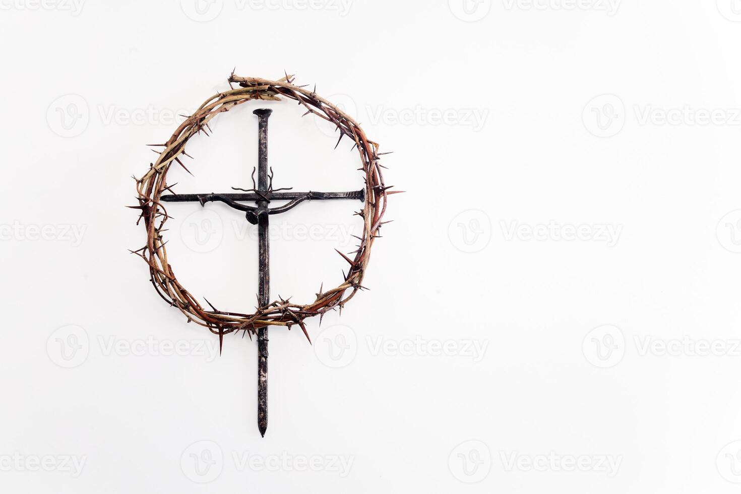 A crown of thorns encircles a simple black metal cross, photo