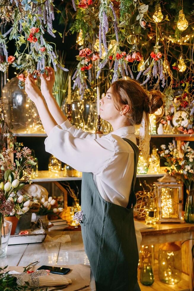 A woman in her florist shop collects bouquet of flowers. The concept of a small business. Bouquets of tulips for the holiday on March 8. photo