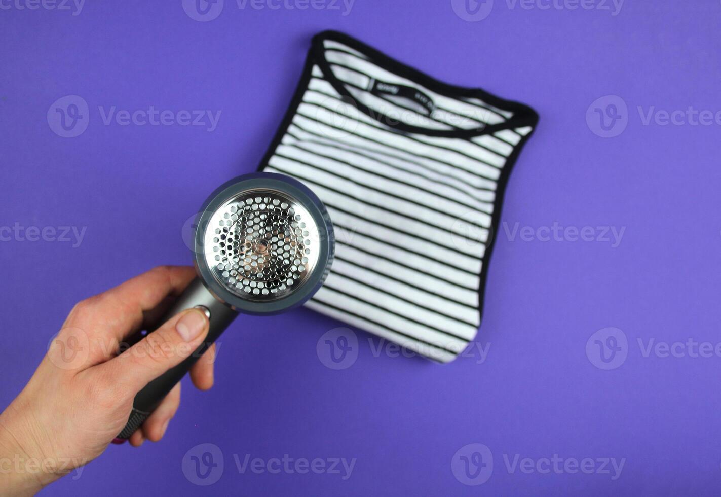 A woman's hand is about to clean lint from clothes. photo