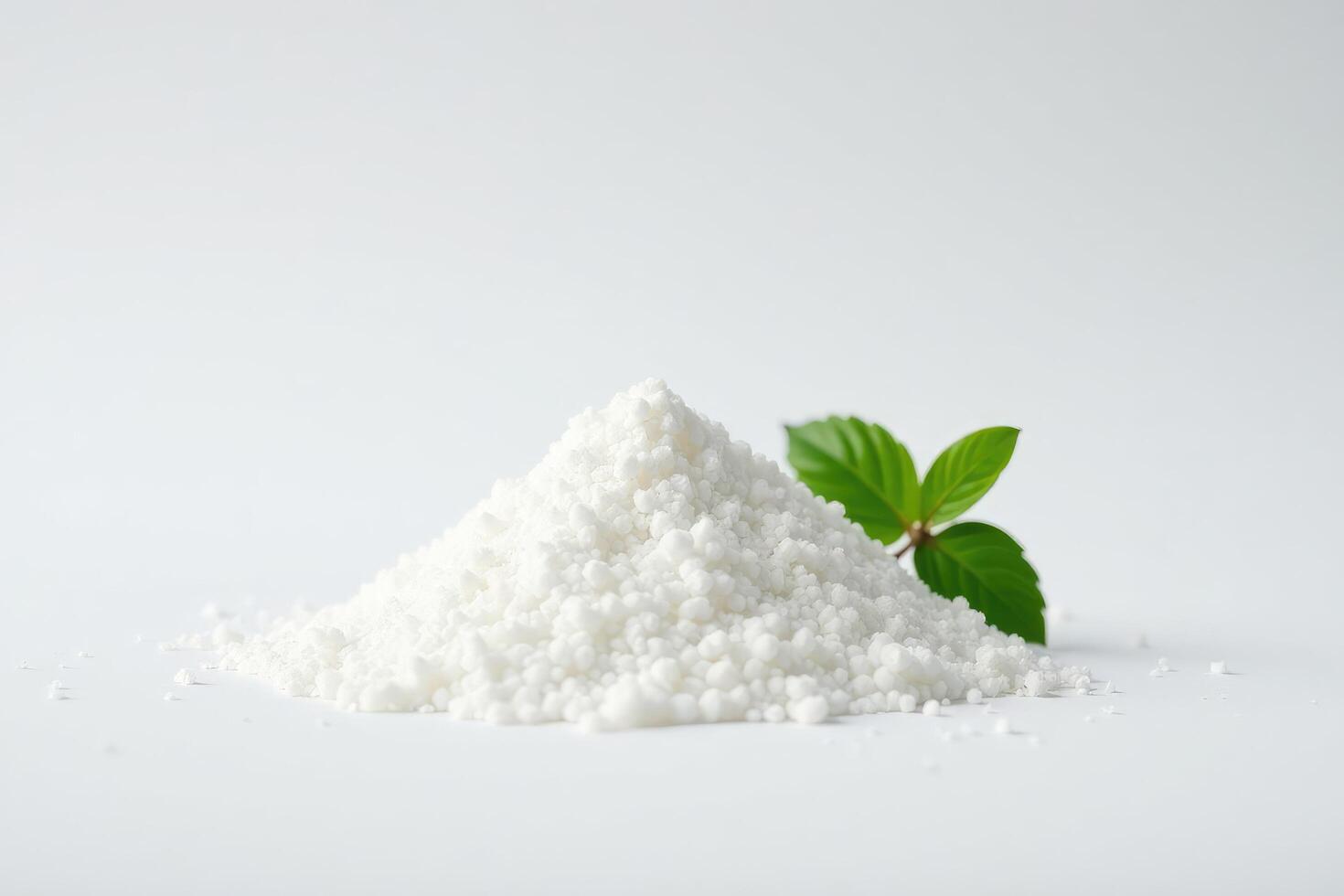 A pile of white sugar with a leaf on top photo