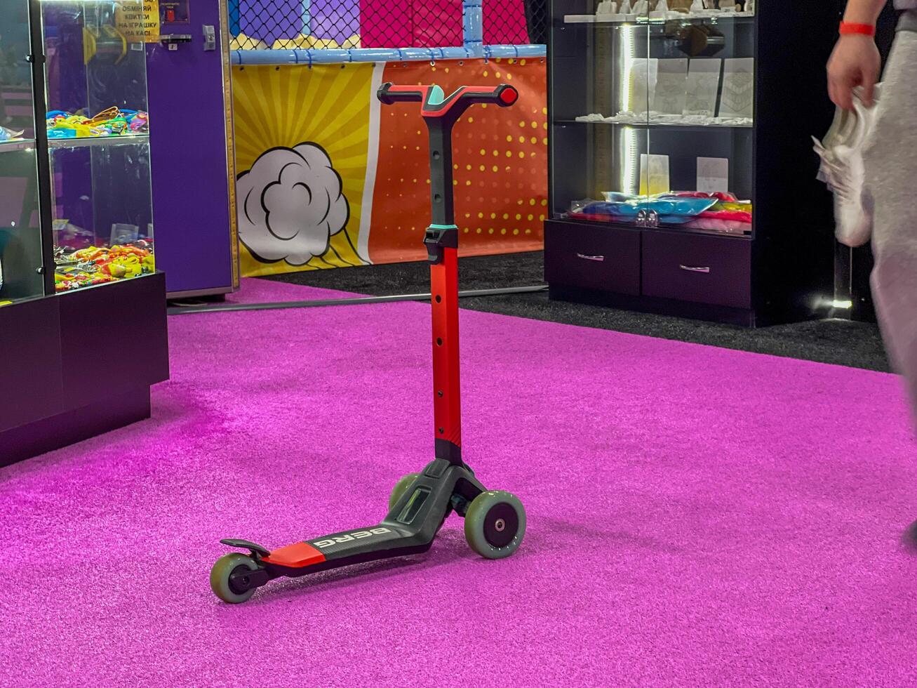 Modern scooter standing on purple carpet in toy store photo