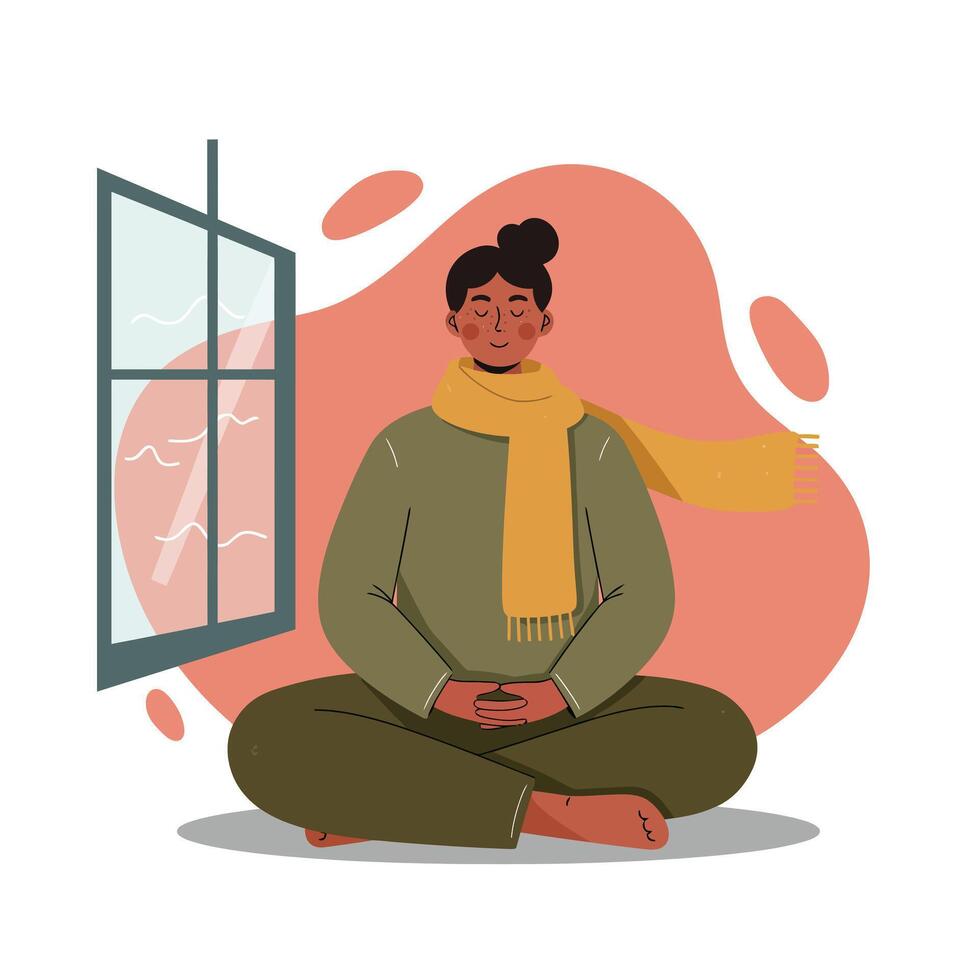 Woman meditating in warm scarf and comfortable clothing near open window with soft natural light indoors calm atmosphere vector