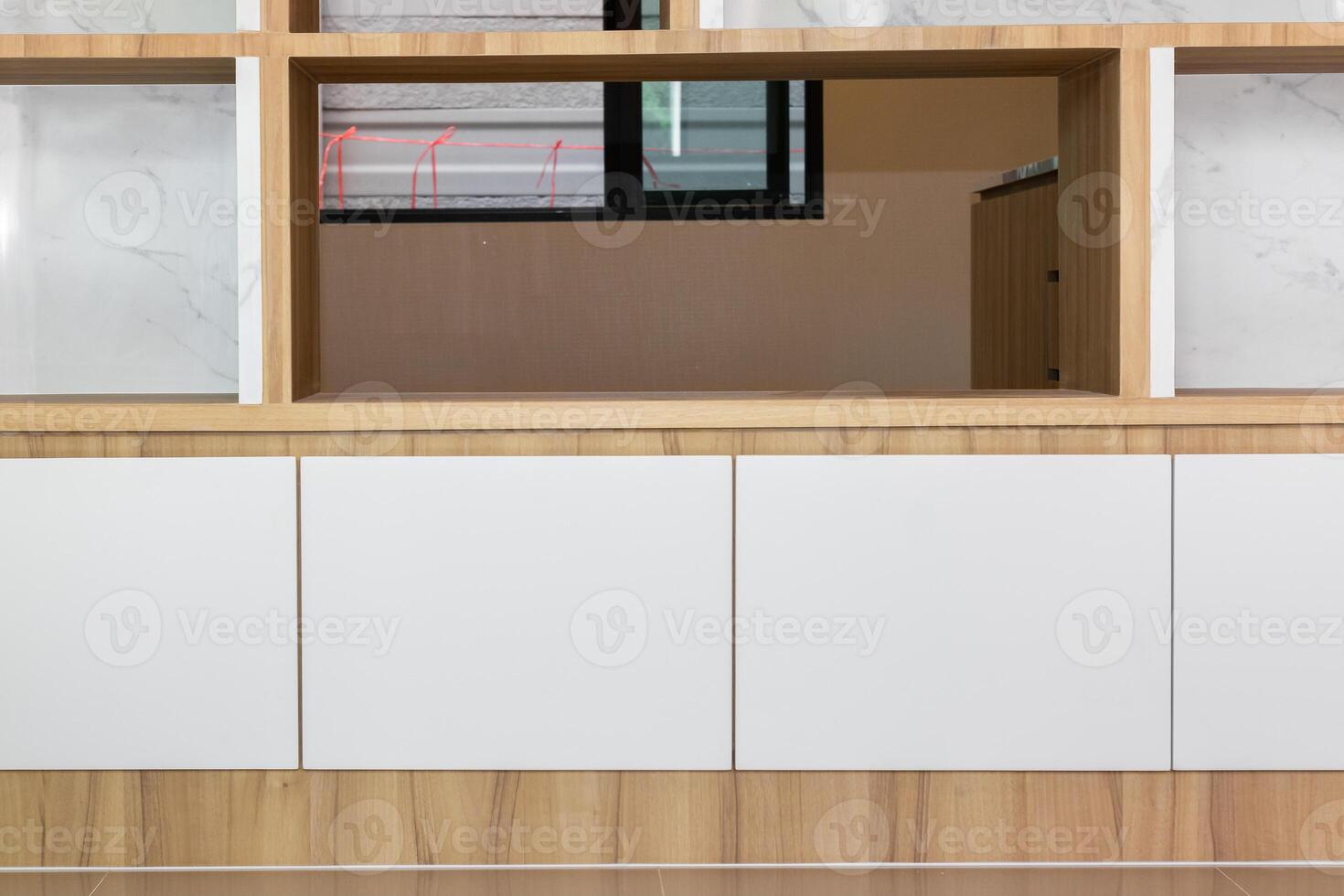 A white cabinet with wooden shelves and a window photo