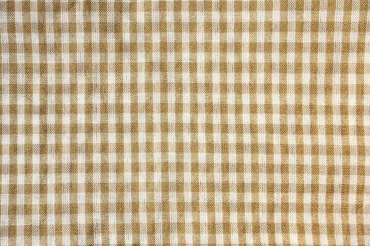 Square checkered brown and white colored picnic table cloth texture isolated on horizontal background from top angle view. photo
