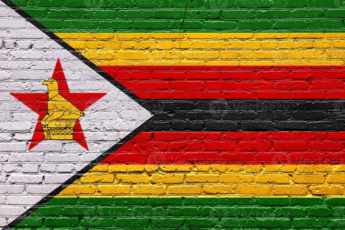 Grunge and weathered flags of zimbabwe and South Africa on a textured brick wall photo