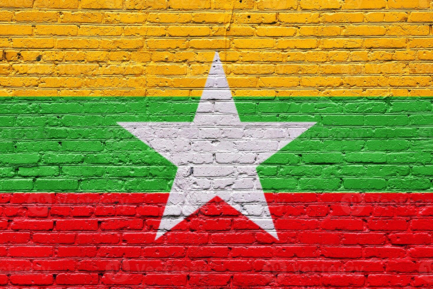 myanmar flag painted on a weathered brick wall with a vintage and grunge texture photo