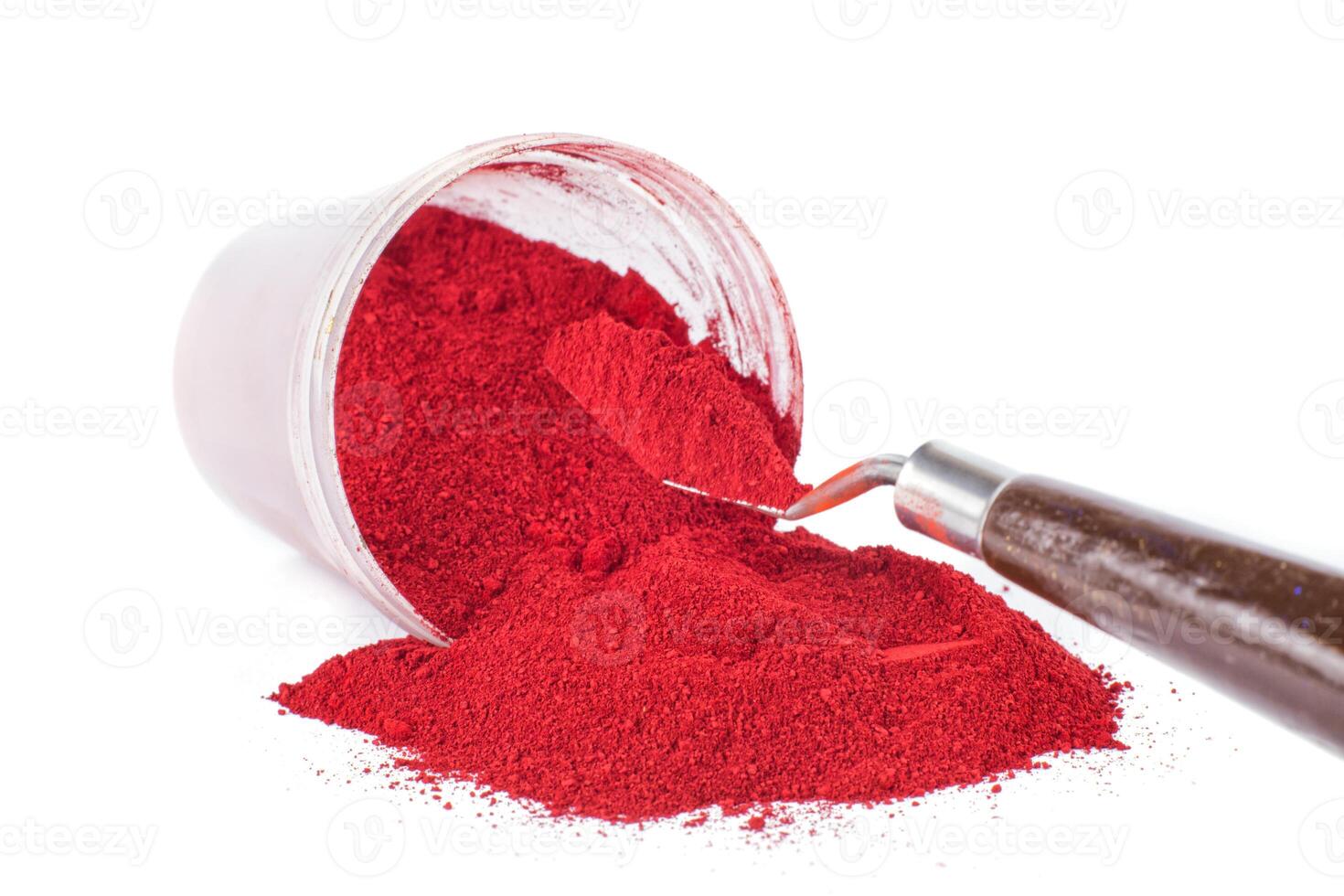 Bright Red Pigment Spilled From Container With a Spatula photo