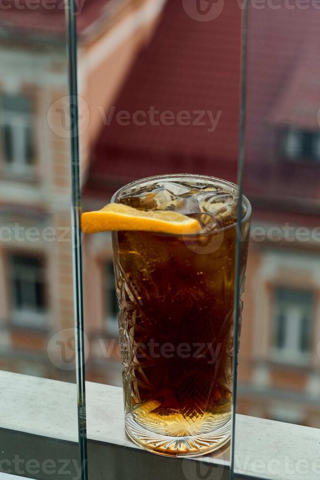Glass of ice tea with lemon on the terrace of a restaurant photo