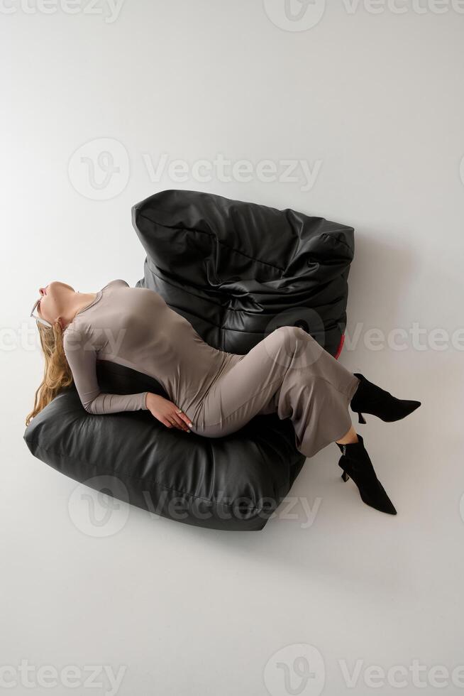 High angle view of businesswoman sleeping on bean bag chair in office photo
