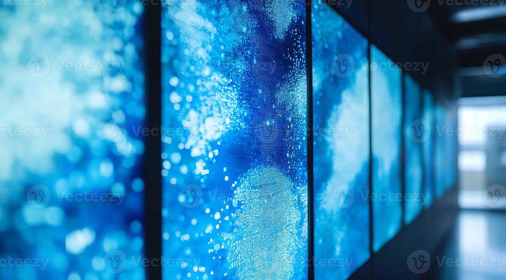 A row of large digital displays showcasing abstract blue and white patterns in a modern minimalist setting. photo